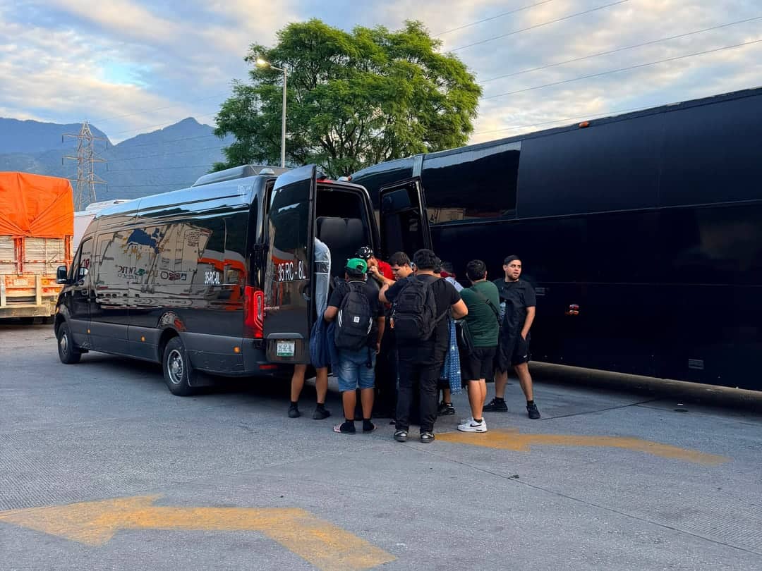 Staff de producción abordando una Sprinter junto al autobús de gira