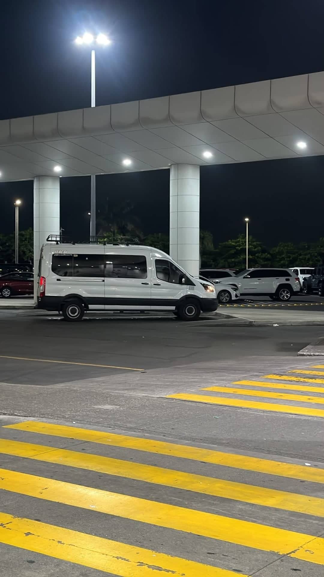 Unidad esperando de noche bajo el techo de llegadas de la terminal