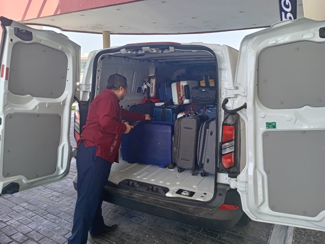 Operador acomodando equipaje de un grupo en la caja de una Ford Transit Cargo